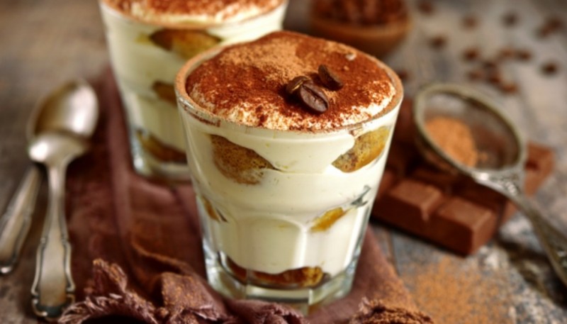 Procedimiento para preparar un tiramisú en vaso 1. Preparar café y dejarlo enfriar.  2. Humedecer las vainillas en el café. Para ello, depositar la infusión en un plato hondo y sumergir las galletitas.  3. Mientras, batir dos yemas de huevo (las claras reservarlas aparte) con el azúcar hasta crear una espuma consistente.  4. Integrar el queso crema tipo mascarpone a la mezcla.