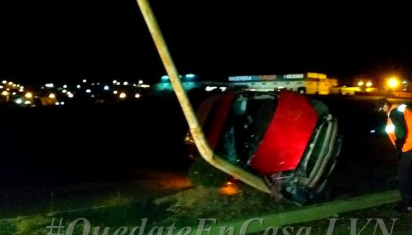 El auto volcado contra una palma de iluminación. 